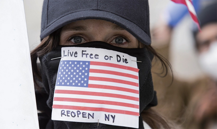 한 여성 시위자가 4월 22일 미국 뉴욕 의사당 건물 앞에서 ‘자유가 아니면 죽음을, 뉴욕을 다시 열어라’는 글을 붙인 마스크를 쓰고 코로나19 봉쇄 정책에 항의하는 시위를 벌이고 있다. / 사진:AFP=연합뉴스